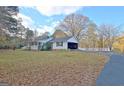 This home features a covered parking area, a long driveway, and beautiful surrounding trees at 435 Crabapple Rd, Fayetteville, GA 30215