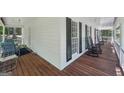 Wrap around porch of home with white siding, dark shutters, and rocking chairs at 230 Vienna Way, Douglasville, GA 30134