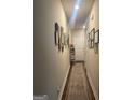Inviting hallway with hardwood floors, decorated walls, and a clear path to the front door at 2635 Lovejoy Crossing Ln, Hampton, GA 30228