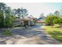 Beautiful home exterior showcases mature trees, a circular driveway, and a lovely water fountain at 1010 Forest Overlook Sw Dr, Atlanta, GA 30331