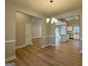 Open-concept living area featuring hardwood floors, neutral walls, and chandelier at 344 Dylan Way, Mcdonough, GA 30252