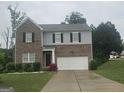 Two-story home featuring brick and siding, a two-car garage, and a well-maintained front lawn at 7253 Lacey Dr, Douglasville, GA 30134
