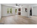 Open-concept living room with wood floors, ceiling fan, and kitchen view at 2714 Haynescrest Dr, Grayson, GA 30017