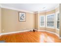 Cozy room with hardwood flooring, neutral paint, crown molding, and a bay window at 145 Windward Hls, Mcdonough, GA 30253