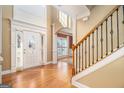 Grand foyer with hardwood floors, high ceilings, decorative columns, and a staircase at 145 Windward Hls, Mcdonough, GA 30253