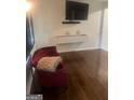 Cozy living room featuring hardwood floors, modern floating cabinet, and a comfortable accent chair at 785 Ne South Pine St, Conyers, GA 30012