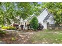 Side view of a white house showcasing well-maintained landscaping and mature trees at 19 Indian Bluff Dr, Sharpsburg, GA 30277
