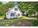 White home with dark shutters, surrounded by lush greenery and a well-kept lawn at 19 Indian Bluff Dr, Sharpsburg, GA 30277