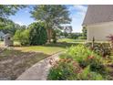 Landscaped front yard featuring colorful flowers and greenery along a walkway at 19 Indian Bluff Dr, Sharpsburg, GA 30277