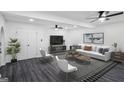 Cozy living room offers a white sofa, ceiling fans, a black and white rug, and a decorative indoor plant at 5490 Chemin De Vie, Sandy Springs, GA 30342