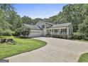 Well-maintained home with a two-car garage, a covered porch, and an expansive driveway at 109 Cannon Rd, Sharpsburg, GA 30277