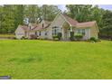 Beautiful front exterior featuring an attached garage, dormer windows, and a well-manicured lawn at 260 Sams Dr, Fayetteville, GA 30214