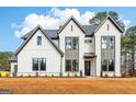 Attractive home with modern design elements, white brick and trim, landscaped yard, and ample windows at 3735 Tamiami Trl, Cumming, GA 30041