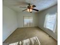 Neutral bedroom featuring a ceiling fan, natural light, and neutral carpet at 102 Crystal River Dr, Riverdale, GA 30274