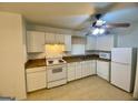 Bright kitchen with white cabinets, appliances and a ceiling fan with overhead lighting at 102 Crystal River Dr, Riverdale, GA 30274