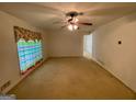 Spacious living room with a ceiling fan and large windows overlooking the landscaped yard at 102 Crystal River Dr, Riverdale, GA 30274