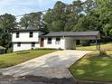 Charming two-story home with a manicured lawn, a carport, and freshly painted exterior at 7340 Chalk Way, Riverdale, GA 30296