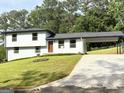 Charming two-story home with a manicured lawn, a carport, and freshly painted exterior at 7340 Chalk Way, Riverdale, GA 30296