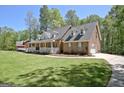 Beautiful brick home with a charming front porch, lush lawn, and attached garage at 315 Antebellum Way, Fayetteville, GA 30215
