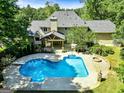Aerial view of a backyard featuring a large in-ground pool, fire pit and covered outdoor living space at 324 Chimney Sweep Cir, Peachtree City, GA 30269