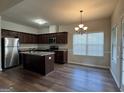 Modern kitchen with stainless steel appliances, granite countertops, rich cabinetry, and a functional center island at 6703 Biscayne Blvd, Rex, GA 30273