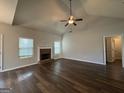 Inviting living room featuring a cozy brick fireplace, vaulted ceilings with fan, and beautiful hardwood flooring at 6703 Biscayne Blvd, Rex, GA 30273
