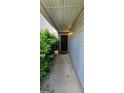Covered front entrance with a black door framed by brick and foliage at 1562 Onalee Dr, Hampton, GA 30228