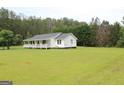 Spacious white home features a lovely covered porch, nestled in a green yard at 124 Wynn Rd, Mcdonough, GA 30252