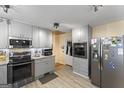 Modern kitchen featuring sleek gray cabinets, stainless steel appliances, and stylish tile backsplash at 2545 Rockbridge Nw Rd, Conyers, GA 30012