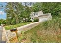 A charming home sits amongst lush trees, showcasing its stone accents and curb appeal at 1960 Morning Nw Walk, Acworth, GA 30102
