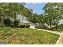 A charming home sits amongst lush trees, showcasing its stone accents and curb appeal at 1960 Morning Nw Walk, Acworth, GA 30102