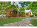 Brick home surrounded by mature trees and landscaping, providing shade and privacy with a curved walkway at 9255 Betony Wood Trl, Jonesboro, GA 30236