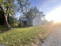 Quaint cottage with a covered front porch and a well-manicured lawn under a bright, partly cloudy sky at 316 Gaithers Rd, Mansfield, GA 30055