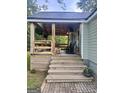 Inviting covered front porch with wooden furniture, a swing, an elegant chandelier, and charming rustic details at 316 Gaithers Rd, Mansfield, GA 30055
