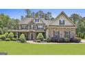 Charming two-story home with a stone and siding exterior, well-maintained landscaping and inviting covered porch at 101 Sumner Place Ct, Peachtree City, GA 30269