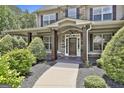 Close up of a welcoming covered porch with stone columns and well manicured shrubs at 101 Sumner Place Ct, Peachtree City, GA 30269