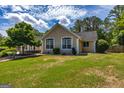 The tan home features large white trimmed windows, green yard and beautiful landscaping at 255 Mcintosh Estates Dr, Sharpsburg, GA 30277