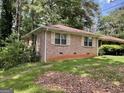 Single story brick home with a yard and mature shade trees at 4116 Warrior Trl, Stone Mountain, GA 30083