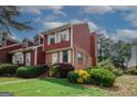 Cozy townhome featuring brick and wood siding, complemented by manicured landscaping at 5461 Park S Pl, Atlanta, GA 30349
