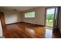 Bright living room with hardwood floors, a large window, and an open doorway at 305 Flat Shoals Church Rd, Stockbridge, GA 30281