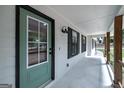 Covered porch with green entry door, black trim, and updated lighting fixtures at 126 Country Acres Ct, Mcdonough, GA 30253