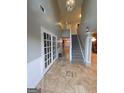 Inviting foyer with staircase, tile flooring, and French doors leading to another room at 75 Trelawney Keep, Covington, GA 30016