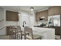 Modern kitchen featuring an island with seating, stainless steel appliances, and sleek countertops at 2024 Piccolo Ct # 228, Mcdonough, GA 30252