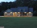 Charming home at night with a beautiful lawn and welcoming exterior lighting at 376 Turner Cir, Mcdonough, GA 30252