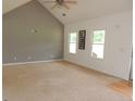Spacious living room with high ceilings, three bright windows, and neutral carpet at 376 Turner Cir, Mcdonough, GA 30252