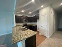View of a kitchen featuring dark cabinets, granite countertops, and stainless appliances at 5257 Carrie Dr, Morrow, GA 30260