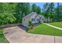 Side view of a home with a long driveway leading to a two-car garage at 6645 N Glen Dr, Cumming, GA 30028