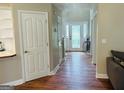 Inviting hallway with wood flooring and a view of the decorative glass front door at 110 Shelby Oaks Trl, Covington, GA 30016