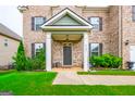 Inviting covered front porch with white columns, manicured lawn, and lush landscaping at 4752 Albany Way, South Fulton, GA 30331