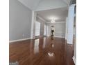 Bright living room with hardwood floors, chandelier, and tall ceilings with decorative columns at 3773 Summer Rose Dr, Atlanta, GA 30341